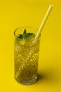 Chia water drink with lemon and mint on colored background