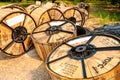 Chiang Mai/Thailand - April 17, 2019: Close-up of wooden and steel reels of black and blue telecommunication cables lying on the g