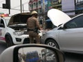 Chiang Mai, Thailand / April 4, 2019: A traffic police help charging a battery of a broken car in the middle of the street in