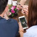 CHIANG MAI, THAILAND - FEBRUARY 21st, 2018: Hands of four teenagers use Apple smartphone together on table