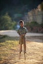 Chiang Mai / Thailand - Jan 16 2016 : A boy playing Gong Keng is a Thai traditional toy that uses bamboo to make two legs to walk