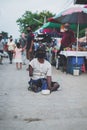 CHIANG MAI, THAILAND - July 5, 2021 : Beggar with crippled arms and legs solicit donations of money and items in the flea market