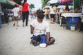 CHIANG MAI, THAILAND - July 5, 2021 : Beggar with crippled arms and legs solicit donations of money and items in the flea market