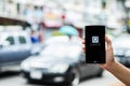 CHIANG MAI,THAILAND - JULY 17, 2016 : A man hand holding Uber app showing on LG G4 on road and red car, Uber is smartphone Royalty Free Stock Photo