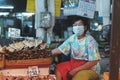 CHIANG MAI, THAILAND - JUNE 30, 2021: Asian Thai vendors wearing masks are selling dried fish at a market in Chiang Mai, Thailand