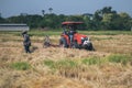 CHIANG MAI, THAILAND - May 20, 2021 : Tractors and workers are harvesting dried straw. in Chiang Mai, Thailand