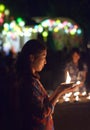 Young Asian girl light the candle to pray in Loi Krathong festival in Thailand