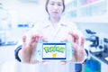 Chiangrai, Thailand - August 16th, 2016 : Asia woman medical technician holding a smart phone and show Pokemon Go logo in