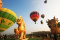 Coloful Balloons free flying in the atmosphere with golden Lion statue in Thailand International Balloon Festival at Singha Park