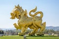 The statue of golden lion on a field with blue sky background, at Singha park Chiangrai Royalty Free Stock Photo