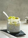 Chiaseed served in a glass jar topped with yogurt and kiwi fruit.