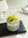 Chiaseed served in a glass jar topped with yogurt and kiwi fruit.