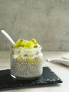 Chiaseed served in a glass jar topped with yogurt and kiwi fruit.