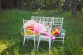 Chiavari chairs on grass with bouquet flowers