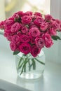 A chic bouquet of small pink roses in a jar on the windowsill. Cute still life