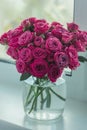 A chic bouquet of small pink roses in a jar on the windowsill. Cute still life