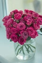 A chic bouquet of small pink roses in a jar on the windowsill. Cute still life