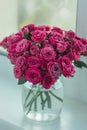 A chic bouquet of small pink roses in a jar on the windowsill. Cute still life