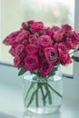 A chic bouquet of small pink roses in a jar on the windowsill. Cute still life