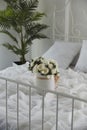 Chic and cozy bedroom decor with white roses and palm. Serene and airy bedroom interior Royalty Free Stock Photo