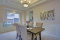 Chic dining room accented with wall panel mouldings and tray ceiling. Royalty Free Stock Photo