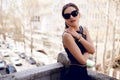 Sensual, brunette woman in sunglasses, sexy black dress, hair ponytail and beautiful face. Royalty Free Stock Photo