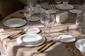 Chic and elegant, gold-plated cutlery and white plates, table setting with empty plates. Beautiful rays of the sun from Royalty Free Stock Photo