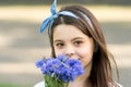 Chic floral look. Small child hold blue flowers outdoors. Beauty look of cute girl. Fashion look of little model