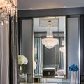 A chic and glamorous dressing room with a mirrored vanity table, a chandelier, and a walk-in closet2, Generative AI