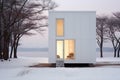 Chic minimalist white tiny house in a snowy landscape at dawn, with warm light spilling from tall windows, offering a