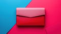 Chic pink and red envelope clutch on a contrasting blue and pink color block background. Royalty Free Stock Photo