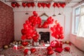 Chic room decoration for Valentines Day. Fireplace near white wall decorated with red heart