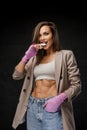 Chic sportswoman in blazer and sports bra, with boxing hand wraps and mouthguard