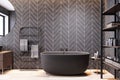 Chic urban bathroom with dark herringbone tiles and stylish wooden shelving. Luxurious feel concept.