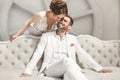 Chic wedding couple groom and bride posing in a white Studio. Happy couple laughing. White dress. White suit. Youth Royalty Free Stock Photo