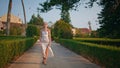 Chic woman walking alley enjoying evening sunlight. Lady walking beautiful park