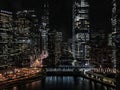 Chicago cityscape illuminated with night lights reflecting off of the Chicago River.