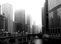 Chicago in the fall under fog with Chicago River, skyscraper office towers in monochrome.