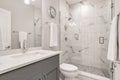 White bathroom with a marble tiled shower.