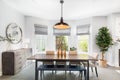 A modern dining room with a light hanging from above.