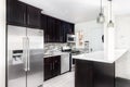 A small kitchen with dark cabinets and a white counter top.