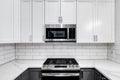 White kitchen with stainless steel appliances.