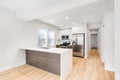 Modern white kitchen with wood floors. Royalty Free Stock Photo