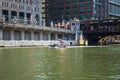 Metropolitan Water Reclamation District of Greater Chicago boat crosses the Chicago River by the Merchandise Mart as it cleans up Royalty Free Stock Photo