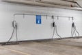 An electronic car charging station in a concrete parking garage. Royalty Free Stock Photo