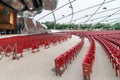 Red concert chairs in the Jay Pritzker Pavilion, located centrally in Millennium Park in Chicago.