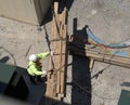 Looking down on a construction worker who is operating a remote controled crane to move a