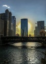Chicago Loop as the glowing sun sets over the Chicago River as elevated `el` train crosses the water while kayaks float by. Royalty Free Stock Photo