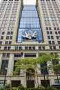 Chicago public art, abstract flame sculpture on building with reflective blue windows and green tree Royalty Free Stock Photo