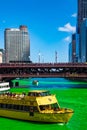 Chicago Water Taxi carrying tourists across a dyed-green Chicago River on St. Patrick`s Day